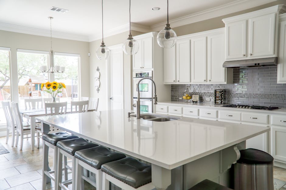 pexels-photo-1080721-1080721-1 Spacious modern kitchen with white cabinets and island in natural light.